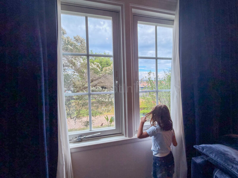 child looking out window at hotel amsterdam huis ten bosch